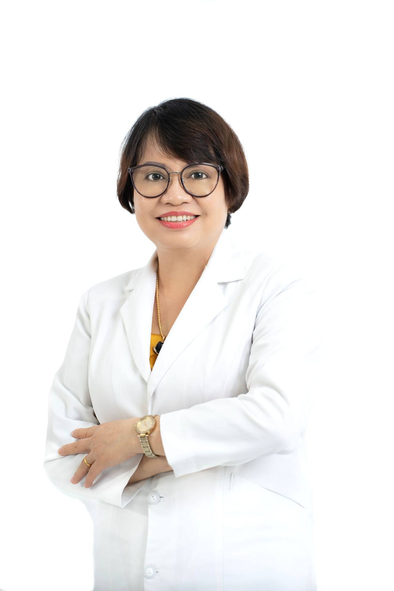 Nữ bác sĩ tóc ngắn, đeo kính gọng tròn, mặc áo blouse trắng, khoanh tay và mỉm cười trên nền trắng